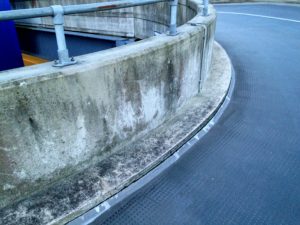 Crack along edge of asphalt car park ramp